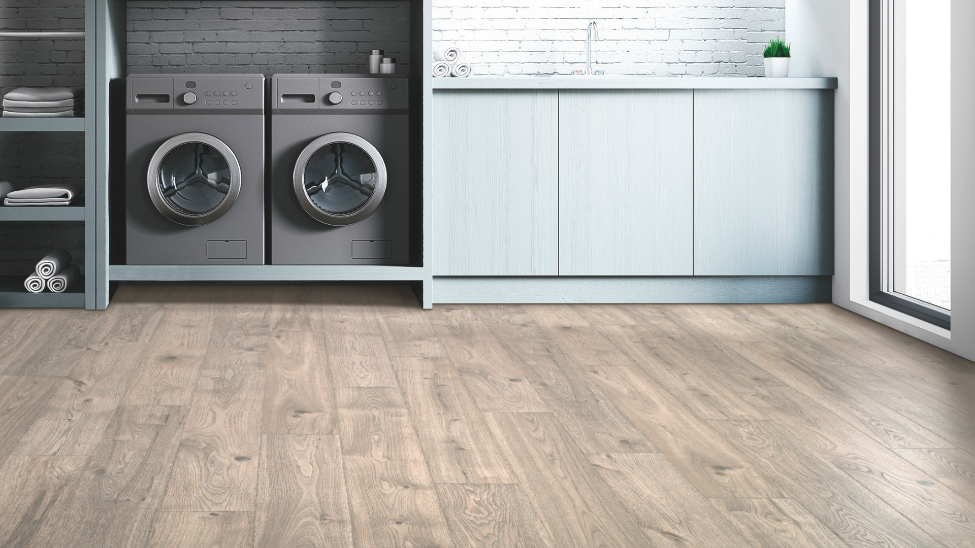 Laminate flooring in a laundry room with built-in light blue cabinetry